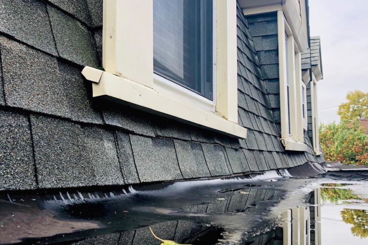 Image of house with water on roof and homeowners wondering what to do when your roof is leaking