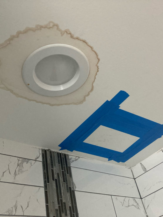 Image of ceiling light with water stains around it, showing evidence of a leak