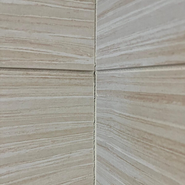 Close up image of a repaired warped bathroom tile